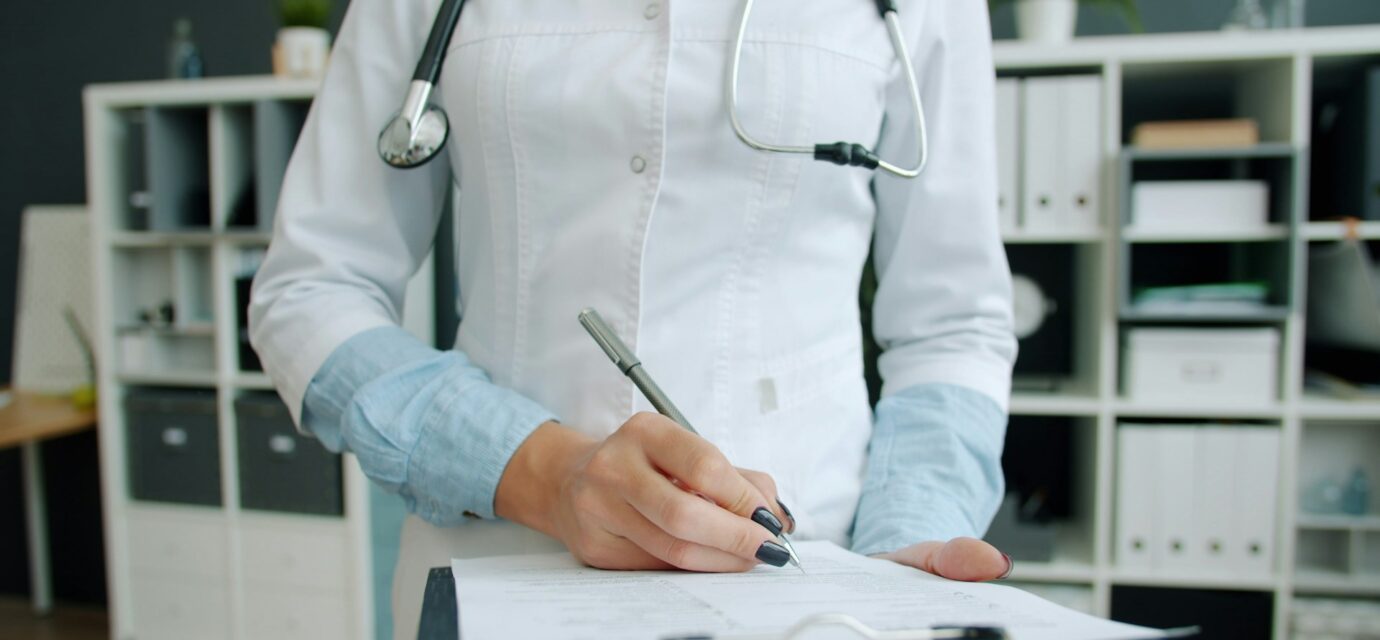 Врач заполняет анамнез в блокноте