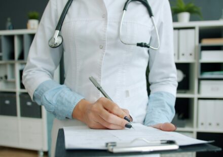 Врач заполняет анамнез в блокноте