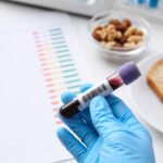 Пробирка с кровью на фоне бланка теста на пищевую чувствительность